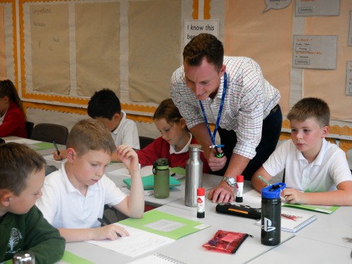 Trainee teacher helps young girl with her work