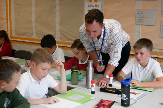 Trainee teacher helps young girl with her work