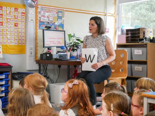 Female student raises hand in class
