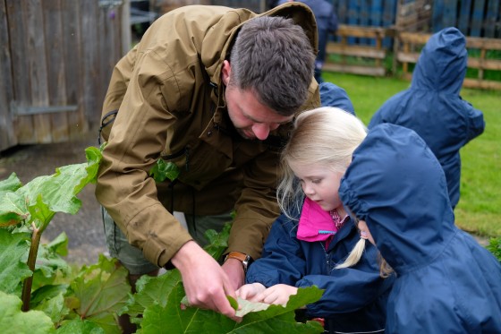 Teacher helps students look at leaves outside